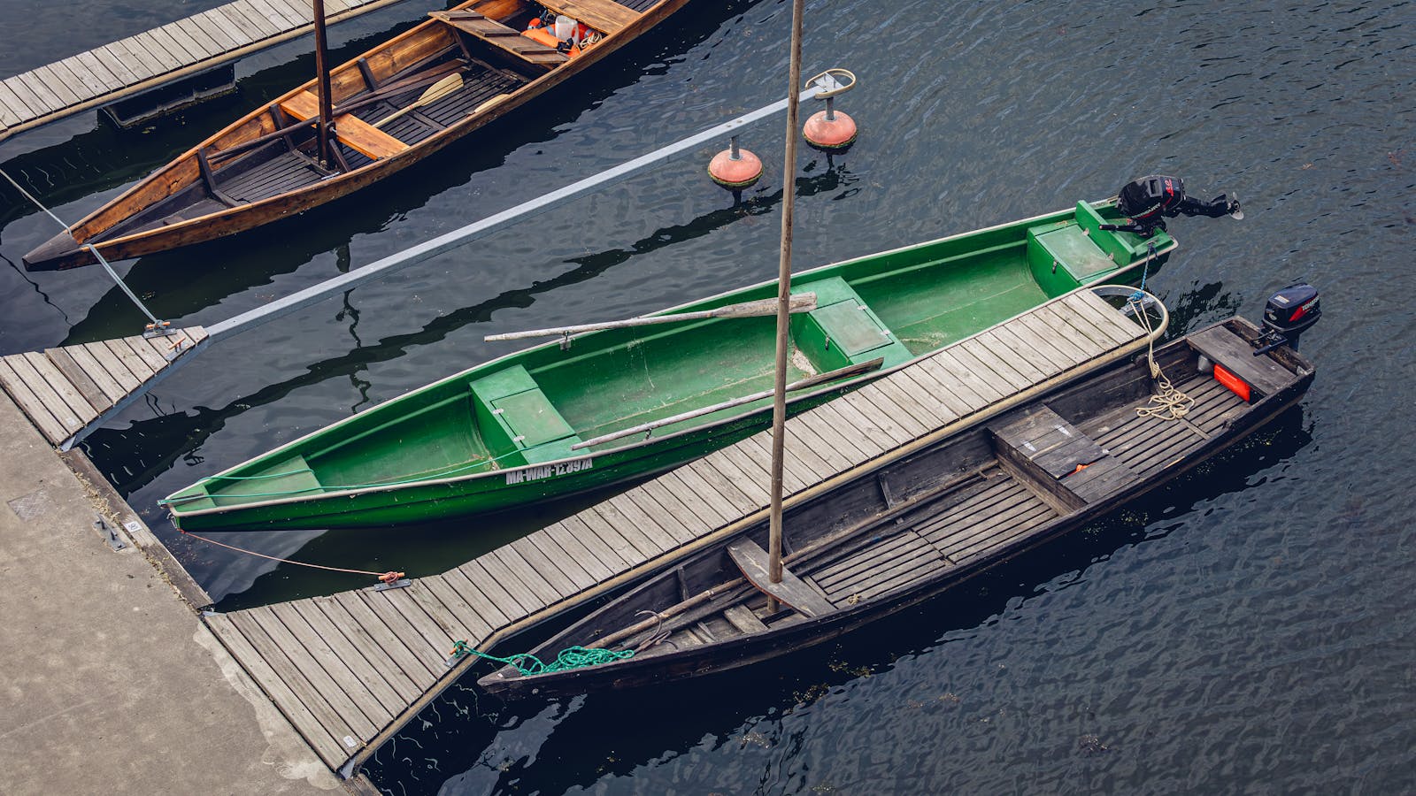 Aerial view of old wooden boats moored at a wooden dock, calm water
